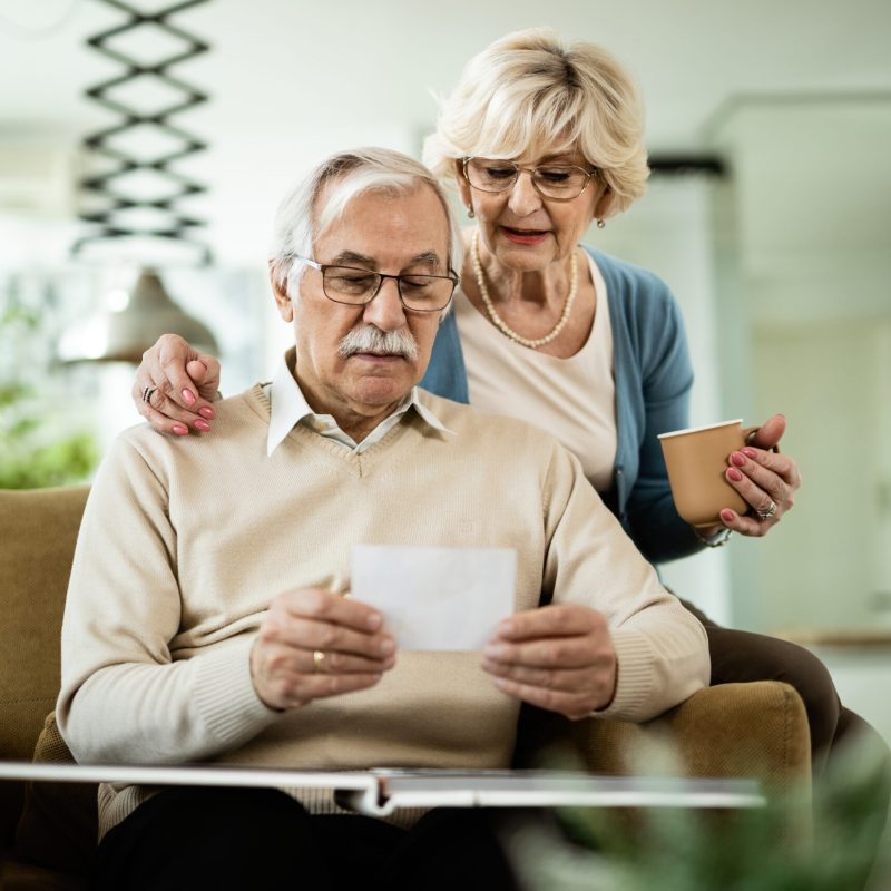 Senior couple looking at their photos while relaxing at home.